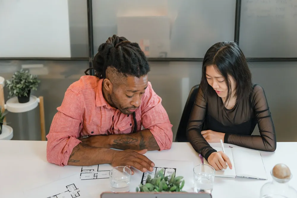 Deux collègues discutant de plans dans un bureau