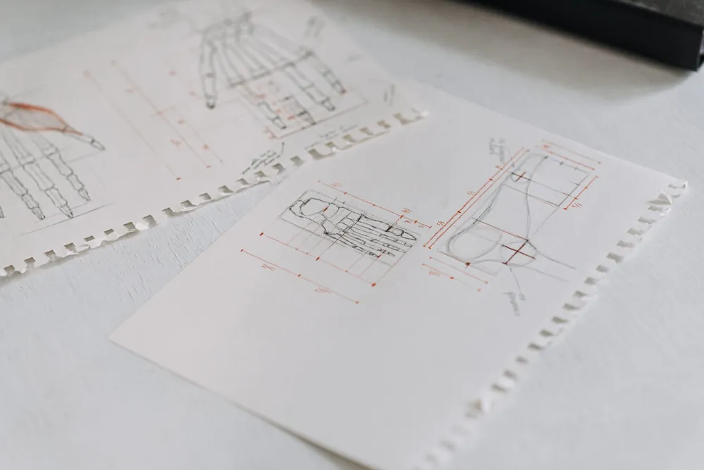 Des plans techniques détaillés sont disposés sur une table pour un projet d'ingénierie
