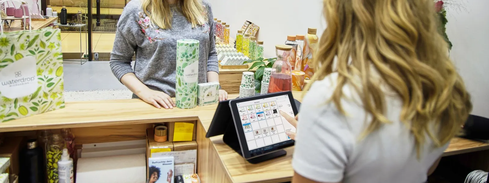 Une cliente règle ses achats à une caisse dans un commerce