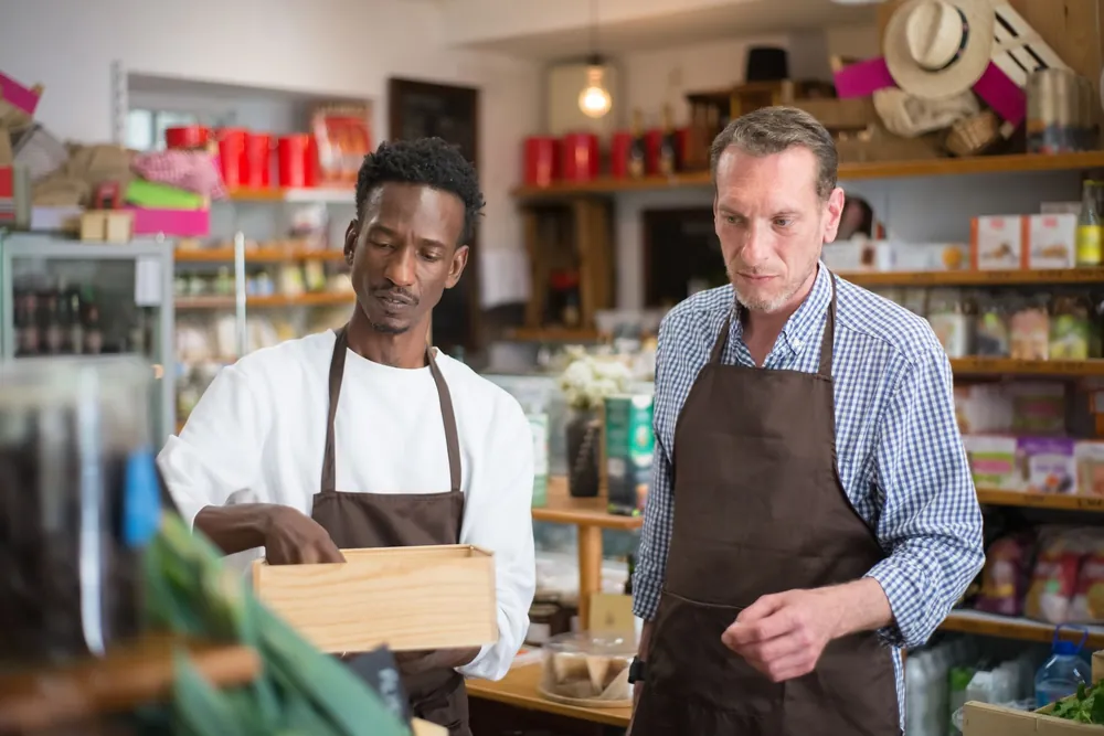 Deux employés rangent des produits sur les étagères d'un magasin d'alimentation