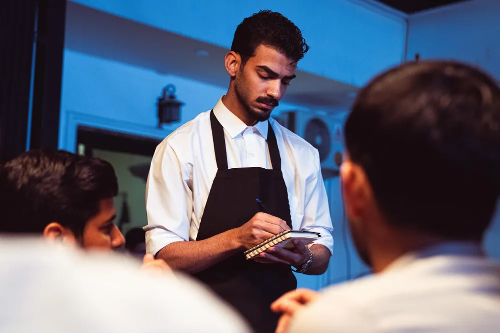 Serveur prenant la commande d'un client dans un restaurant chaleureux