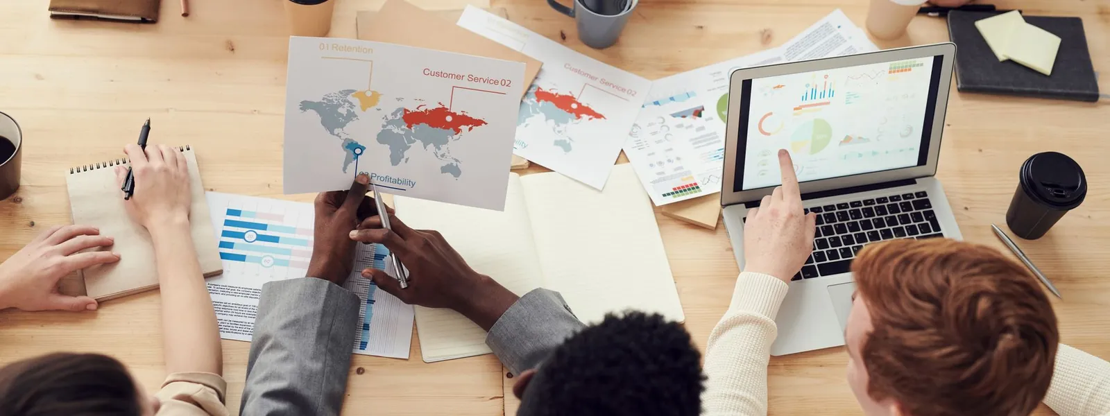 Équipe marketing réunie autour d'ordinateurs et de graphiques lors d'une réunion