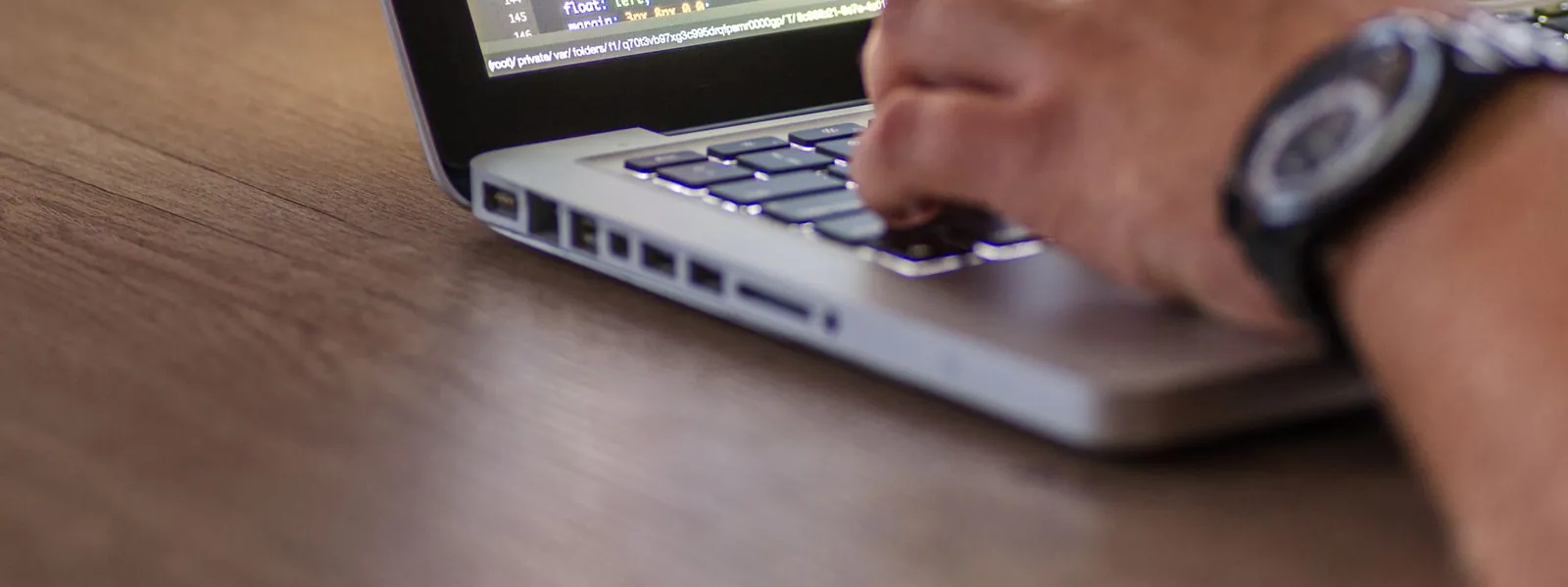 Mains d'une personne tapant du code sur un ordinateur portable
