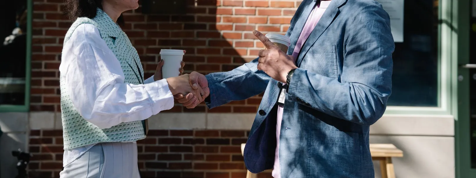 Deux collègues se serrant la main lors d'une rencontre professionnelle en extérieur