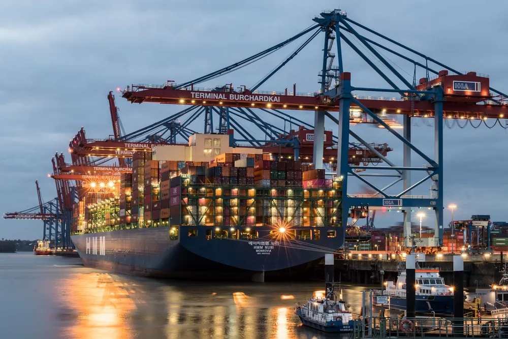 Navires porte-conteneurs amarrés dans un port allemand en soirée