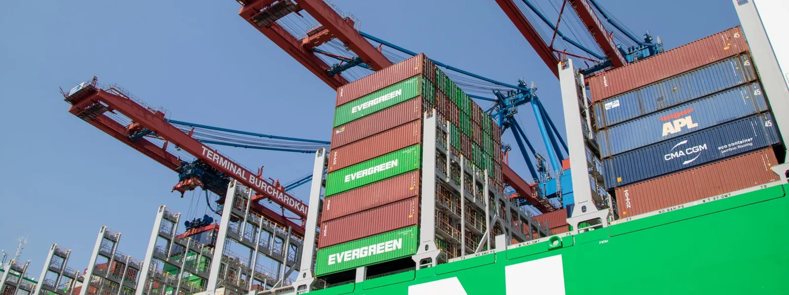 Grues et conteneurs dans un port maritime illustrant le commerce international