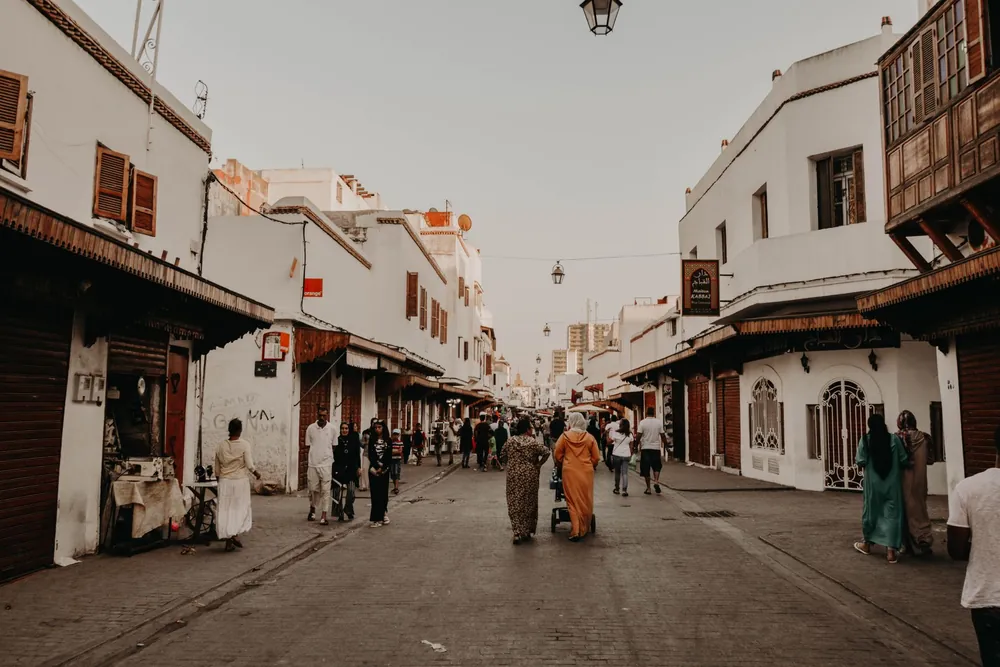 Rue animée de Rabat bordée de commerces et de passants