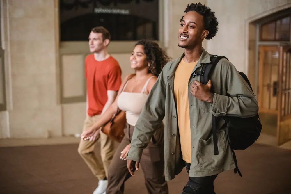 Étudiants souriants discutant dans un couloir de campus universitaire